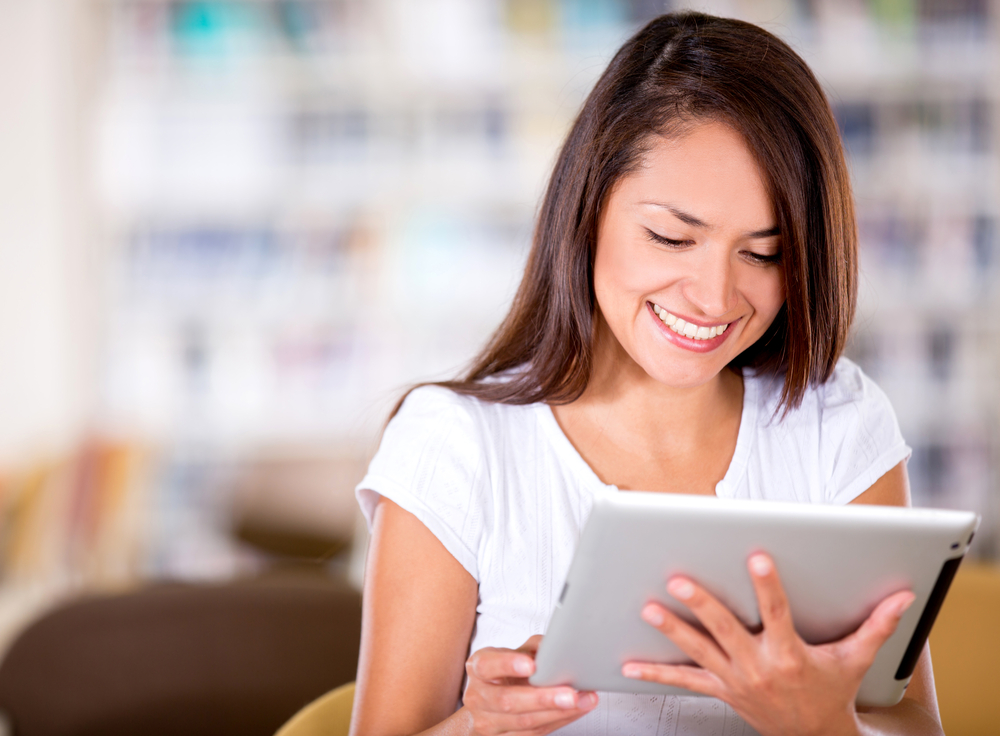 Woman,Reading,At,The,Library,On,An,E-book,Reader